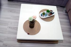 una mesa con dos sombreros y un plato con un cactus en Simona Apartman, en Bitola 8 fotos más