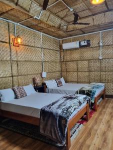 a room with two beds in a room at Alohi The Cottage Homestay in Tezpur