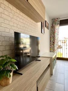 a living room with a large flat screen tv on a brick wall at Puente de la Reina de Teruel in Teruel