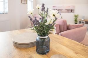 a vase filled with flowers on a wooden table at Host & Stay - The Crow's Nest in Ramsgate +9 photos