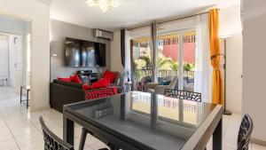 ein Wohnzimmer mit einem Tisch und einem Sofa in der Unterkunft ALIZES BLEUS DE THAU 5 étoiles in Balaruc-les-Bains + 14 Fotos