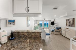 a kitchen and living room with a table and chairs at Beautiful Beach Front Paradise at Pinnacle Port B2-608! in Panama City Beach