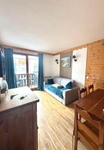 a living room with a couch and a bed in it at Les Orres 1800 - 6 places Plein Sud avec Piscine in Les Orres