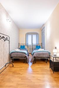 deux lits dans une chambre avec parquet dans l'établissement Il cuore di Torino- 6 ospiti, à Turin