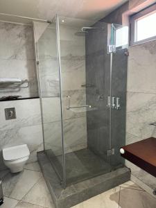 a shower stall in a bathroom with a toilet at The Palms by Eagles Airport Residential in Accra +26 photos