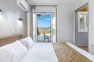 カルダミリにあるVilla Palataki IIIのベッドとガラスの引き戸のある寝室 +41枚の写真