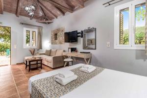 a bedroom with a bed and a living room at Villa Palataki II in Kardamili +42 photos
