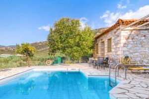 een zwembad voor een stenen huis bij Villa Palataki I in Leptíni +21 foto's