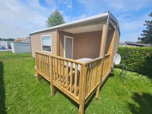 a tiny house with a large deck in a yard at loggia 29 in Biville-sur-Mer