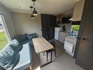 a small kitchen with a small table in a caravan at loggia 29 in Biville-sur-Mer