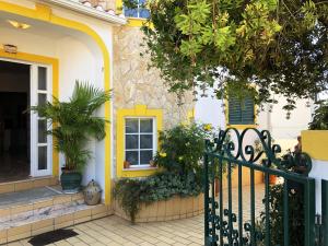 ein gelbes und weißes Haus mit einem Tor in der Unterkunft Casa Bonita in Lagoa