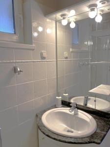 biała łazienka z umywalką i lustrem w obiekcie Apartment Tasha w mieście Ist +25 zdjęć