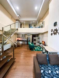 DadapApt Roseville Soho BSD 1 BR Mezzanine with Netflix & Pool by Damaresa的带沙发和楼梯的客厅