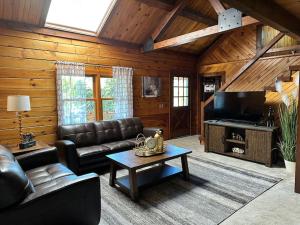 a living room with a couch and a coffee table at Forest Tree Log Cabin in Middletown