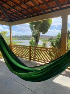 a green hammock on a porch with a view at Casa do Lago Sairé in Sairé +14 photos