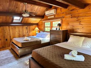 a bedroom with two beds in a log cabin at Forest Tree Log Cabin in Middletown +39 photos