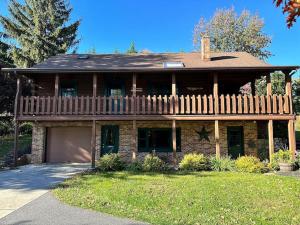 a large brick house with a porch and a fence at Forest Tree Log Cabin in Middletown