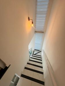 einen Flur mit Treppe mit Licht und Fenster in der Unterkunft Duplex mobiliado no cumbuco in Caucaia