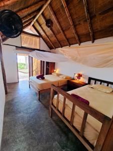 a bedroom with two beds in a room with wooden ceilings at Cabañas La Tortuga in Ayampe