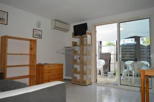 a living room with a sliding glass door to a patio at Maison 4 pièces ARGELES SUR MER AR300-027 in Argelès-sur-Mer