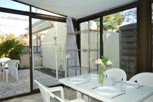 a white table with white chairs on a patio at Maison 4 pièces ARGELES SUR MER AR300-027 in Argelès-sur-Mer