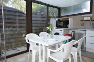 a kitchen with a white table and white chairs at Maison 4 pièces ARGELES SUR MER AR300-027 in Argelès-sur-Mer