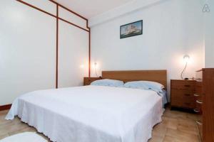 a bedroom with a large white bed and a dresser at App Sebastiano in Avola