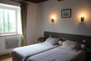 a bedroom with two beds and a window at Gites de la Haie in Plouégat-Moysan