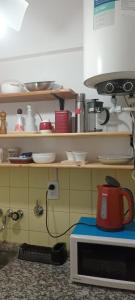 y cocina con microondas y tetera roja. en Belgrano 332, en Bahía Blanca