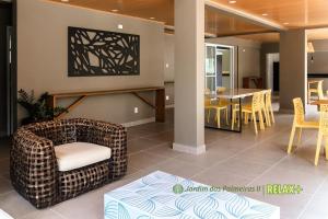 a living room with a chair and a table at Jardim das Palmeiras II - Multipropriedade in Ubatuba