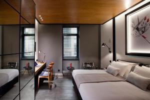 a bedroom with two beds and a desk and chairs at MET34 Athens in Athens