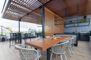 a dining room with a wooden table and chairs at Breeze Residence #111 - Conforto por Carpediem in Tambaú