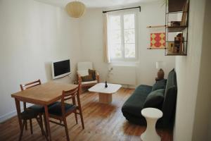 a living room with a green couch and a table at Studio Microchole Chinon in Chinon
