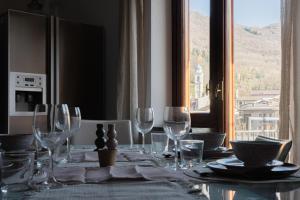 una mesa de comedor con copas de vino y una ventana en Frabosa White Week Elegant APT 4beds 10 min to Ski Station, en Frabosa Sottana 20 fotos más