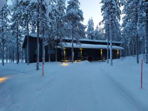 una casa nella neve con alberi innevati di Harjunranta a Kuusamo