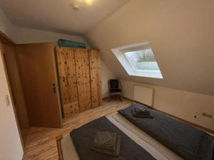 una camera mansardata con letto e finestra di !!!NEU!!! Ferienwohnung an der Harle OG a Carolinensiel
