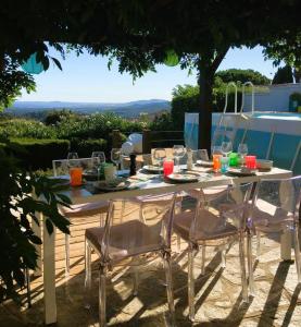 a white table with chairs and wine glasses on it at Villa Cosy pour 6 personnes avec piscine privée et vue panoramique sur les îles et les collines à La Londe les Maures in La Londe-les-Maures