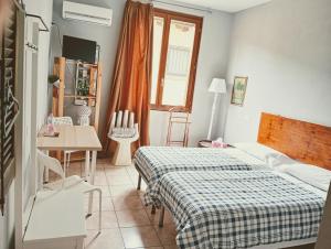 a bedroom with a bed and a table and a window at B&B Franciacorta in Castrezatto
