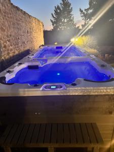 a blue bathtub in a room with a stone wall at Superbe Loft Spa Jacuzzi Cinema in Néris-les-Bains