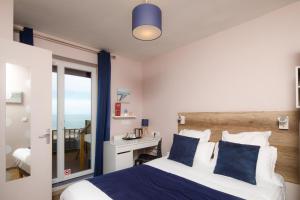 a bedroom with a bed and a view of the ocean at Saint Aubin Logis Hôtel & Restaurant in Saint-Aubin-sur-Mer