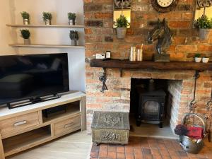 a living room with a fireplace with a television and a horse statue at Corner Cottage in Knaresborough
