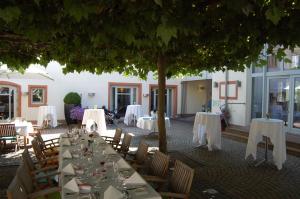 a table set up for a wedding under a tree at Landhotel zum Schwanen mit Restaurant Mona Liza in Osthofen