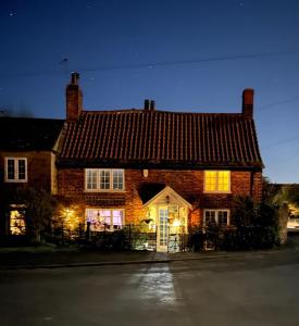 a large brick house with its lights on at Corner Cottage in Knaresborough