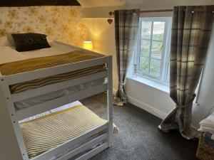 a bedroom with a bunk bed and a window at Corner Cottage in Knaresborough