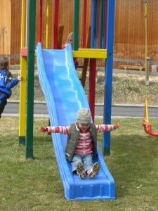 a young child sliding down a slide at a playground at Haus Mooshof in Lermoos +12 photos