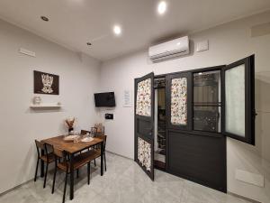 a dining room with a table and a black door at Casa vacanze al teatro in Catania