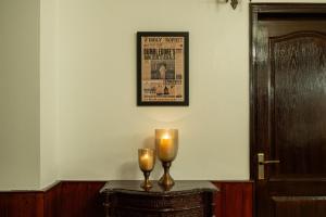 a table with two candles and a picture on the wall at Wizards Den-Harry Potter inspired 3BHK in Mashobra in Mashobra