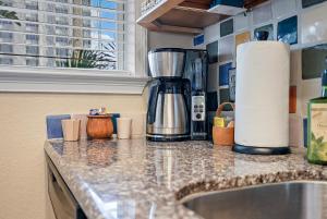 a kitchen counter with a coffee maker on it at Wine-Dine-Sunshine Cozy Flat in The Heart of DTSP in St Petersburg +23 photos