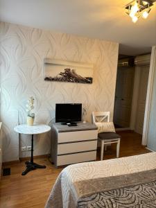 a bedroom with a bed and a desk with a television at La Roseraie in Vitrac