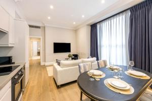 Una cocina y una sala de estar con una mesa y un sofá. en Buckingham & Lloyds Knightsbridge, en Londres 64 fotos más
